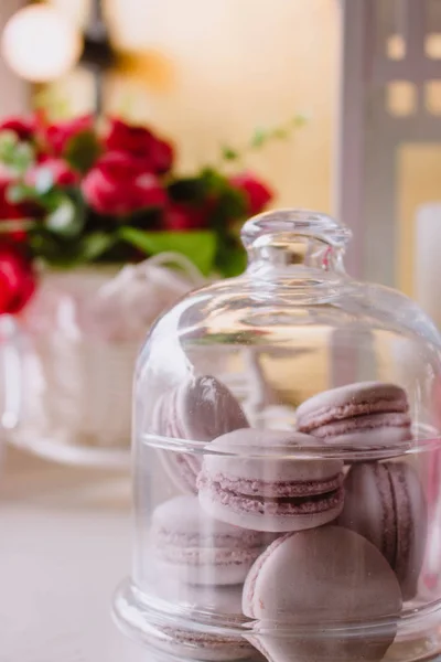 Macarons franceses rosa sob o vidro nas tábuas de madeira, fundo foco macio — Fotografia de Stock