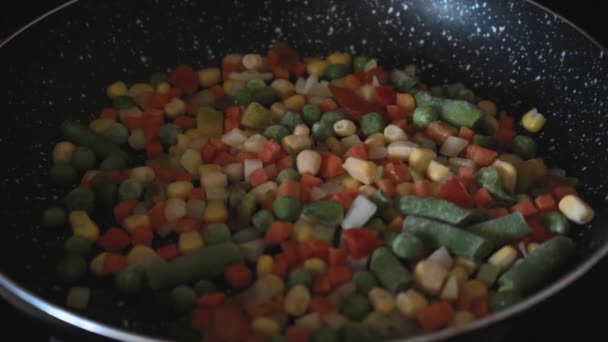 炒冷冻蔬菜 用铲子把蔬菜炒在锅里 把蔬菜混合在平底锅上 晚餐的健康烹饪 — 图库视频影像