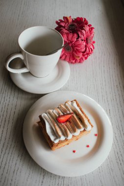Kafede kahve ile yağlı Napoleon. Beyaz arka plan üzerinde taze çilek ile enfes tatlı. Fransız vanilya ahududu milföy çanağı üzerinde