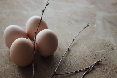 Rustik ahşap arka plan üzerinde dört tavuk organik yumurta. Bahar çiğ taze tarzı.