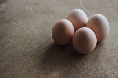 Rustik ahşap arka plan üzerinde dört tavuk organik yumurta. Bahar çiğ taze tarzı.
