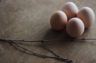 Rustik ahşap arka plan üzerinde dört tavuk organik yumurta. Bahar çiğ taze tarzı.