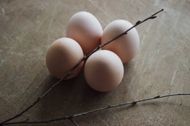 Rustik ahşap arka plan üzerinde dört tavuk organik yumurta. Bahar çiğ taze tarzı.