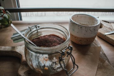 Kahve kapuçino ile cam fincan tiramisu yüksek açı görünümü. Vegsn dükkanında, yerel rahat kafede. Ahşap arka plan, samimi tarzı. Kopyalama alanı