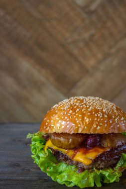 Burger, kıyma pirzisi ile hamburger sandviç, eritilmiş peynir, meyve kiraz ve armut. Ahşap zemin ve hafif ahşap tahta üzerinde üst görünüm.