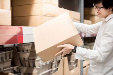 Küçük Asya adam ambar, depo alışveriş veya çalışma çekme ürün raf karton kutu taşıyan ve kavramlar ambalaj