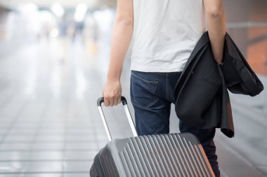 Genç Asyalı casual adam takım elbise ve Bagaj Havaalanı terminal yürürken holding
