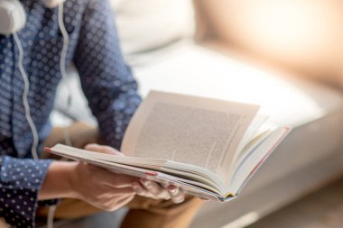 Küçük Asya adam üniversite öğrencisi Kütüphane, eğitim araştırma ve kendi Üniversitesi yaşam kavramları öğrenme kanepe üzerinde kitap okuma