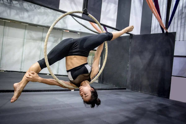 young asian acrobatic woman doing her gymnastics performance on aerial hoop or aerial ring