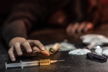 Erkek keş el enjeksiyon şırınga pişmiş kahraman kapmak çalışıyor. Sert uyuşturucu aşırı doz ve bağımlılık kavramı