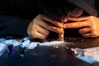Eroin, kokain ya da başka bir narkotik madde banknot kullanarak alarak keş adam. İlaç kötüye kullanımı ve bağımlılığı kavramı