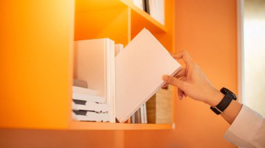 Erkek el seçme ve Halk Kütüphanesi, eğitim araştırma ve kendi Üniversitesi yaşam kavramları öğrenme içinde portakal bookshelf beyaz kitap toplama