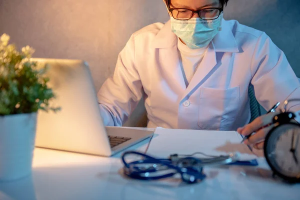 Мужчина Азиатский Врач Маске Работающий Ноутбуком Медицинскими Бумагами Столе Больничной — стоковое фото