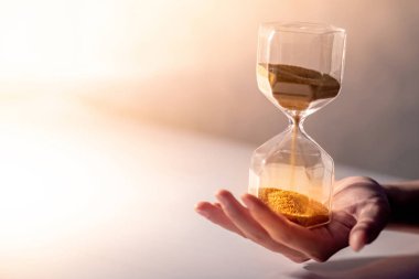 Altın kum erkek yandan modern kum saati şekli ile çalışan kapatın. Zaman geçirmeden ve zamanımız tükeniyor. Aciliyet geri sayım sayacı için iş son tarih kavramı kopya alanı ile