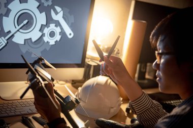 Asya teknik mühendis dron masanın üzerinde araçları sabitleme ile tamiri yedek pervane değiştirme. Erkek teknisyen bakım dron. İnsansız hava aracı (İHA) fotoğraf ve mühendislik kavramı