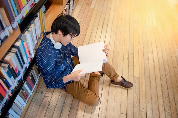Joven Estudiante Universitario Asiático Con Gafas Auriculares Lectura Libro Sentado — Foto de Stock