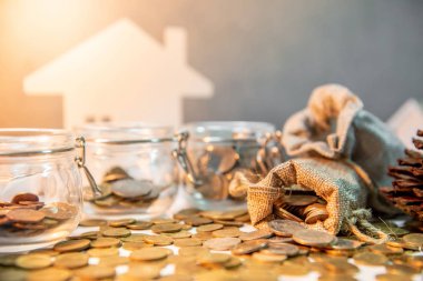 Gelecekteki kavramı için para tasarrufu. Özellik veya gayrimenkul yatırım. Ev ipotek kredi oranı. Altın sikke para çantasını masanın üzerine dışarı dökülmesini ile grubu para birimi cam kavanozlar.