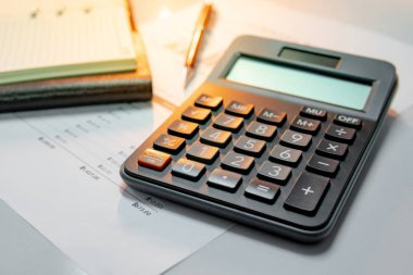 Hesap makinesi, kalem, defter ve Özet raporu evrak ile çubuk grafik ve tablo boş çizgili kağıt sayfası. Finansal veri analizi. İş planlaması ve yönetimi kavramı