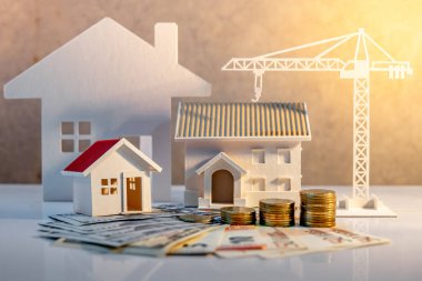 Gayrimenkul veya emlak geliştirme. İnşaat iş yatırım kavramı. Ev ipotek kredi oranı. Ev ve inşaat vinç ile uluslararası banknot para yığını masaya modelleri.