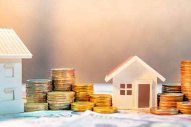 Gayrimenkul veya gayrimenkul yatırımı. Ev kredisi oranı. Emeklilik konsepti için para biriktiriyorum. Masada ev modeli olan uluslararası banknotların para yığını. İş büyüme arkaplanı