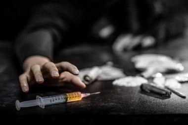 Erkek keş el enjeksiyon şırınga pişmiş kahraman kapmak çalışıyor. Sert uyuşturucu aşırı doz ve bağımlılık kavramı