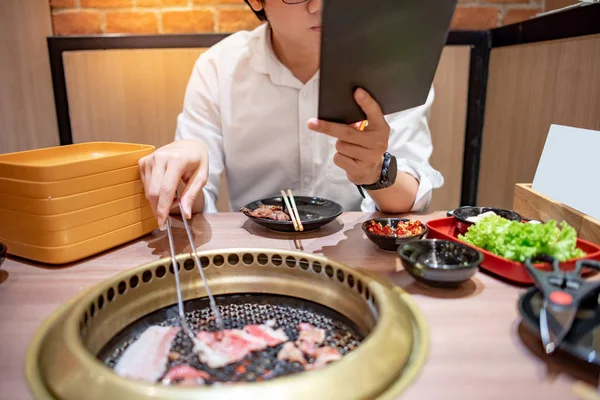 Jonge Aziatische Man Eten Koreaanse Barbecue Buffet Menu Bestellen Tijdens — Stockfoto