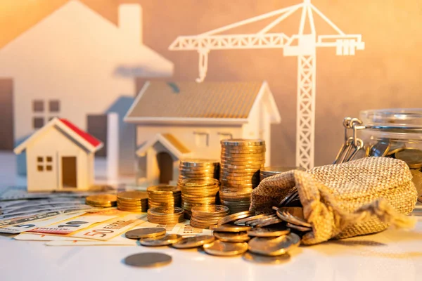 不動産または不動産開発 建設事業の投資概念 住宅ローン貸付利率 国際紙幣計算機 家とクレーンのコイン スタック モデル テーブルの上 — ストック写真