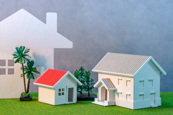 Концепция развития недвижимости или инвестиций в недвижимость. Ставка по ипотечному кредиту. Модели домов и деревьев на зеленой траве
.