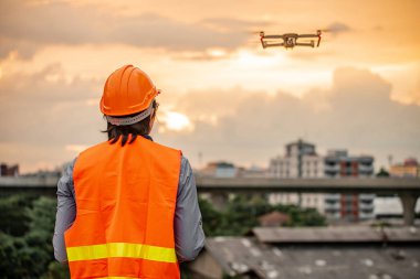 Küçük Asya mühendislik dron günbatımı sırasında inşaat sitesi üzerinden uçan adam. İnsansız hava aracı (İHA) arazi için kullanarak ve inşaat mühendisliği proje sitesi anket oluşturma.