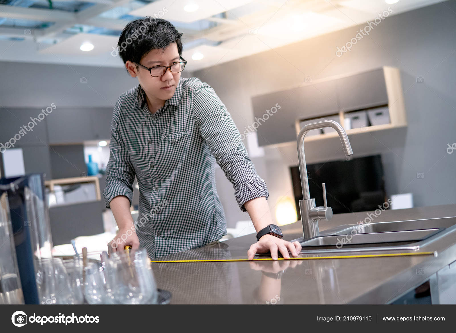 Young Asian Man Using Tape Measure Measuring Granite Countertops