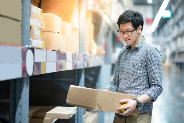 Ung Asiatisk Man Redovisade Kartong Mellan Raden Hyllor Lager Shopping — Stockfoto