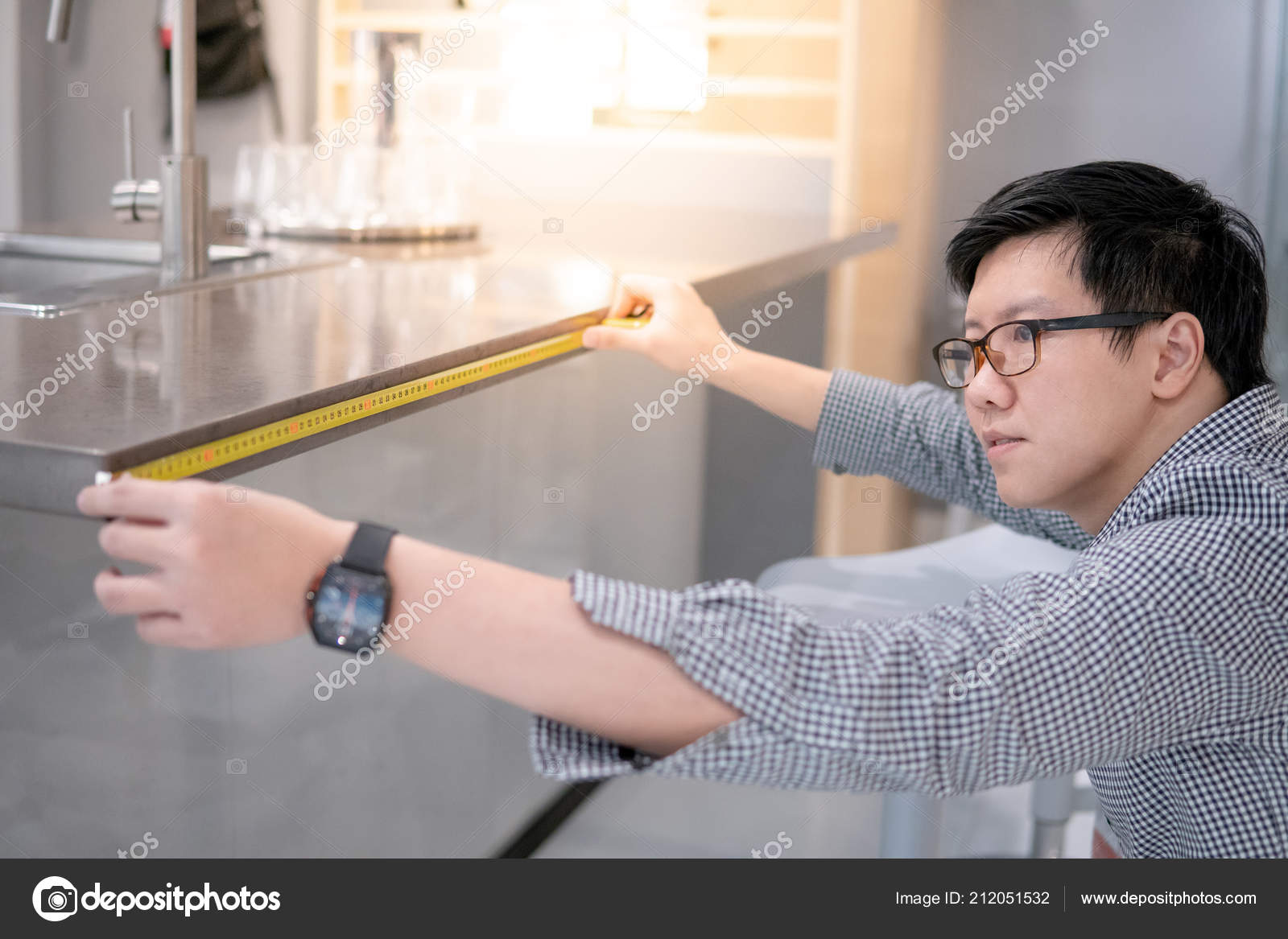 Young Asian Man Using Tape Measure Measuring Granite Countertops