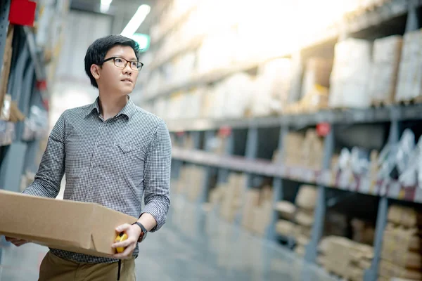 Joven Hombre Asiático Que Lleva Caja Cartón Entre Fila Estantes — Foto de Stock