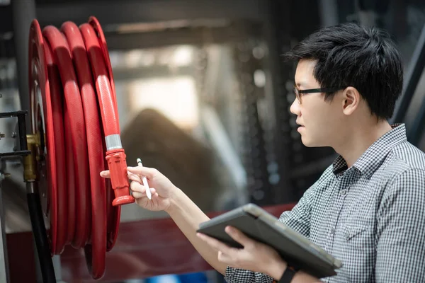 Young Asian Male Technician Checking Red Fire Hose Reel Using — Stock Photo, Image