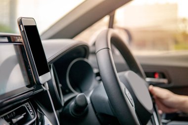 Direksiyon smartphone Gps navigasyon için kullanarak üzerinde tutan erkek sürücü el. Cep telefonu ile modern araba araba konsol üzerinde mıknatıs montaj. Kentsel yaşam tarzı mobil uygulaması teknolojisi ile sürüş