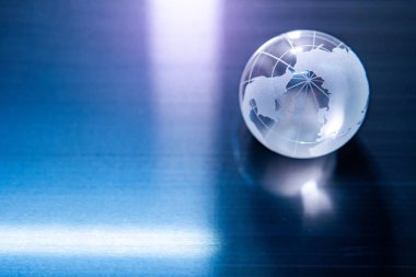 Dünya küre kristal cam mavi parlak masaya yansıtır. Küresel iş ve ekonomi. Çevre koruma veya ekoloji kavramı