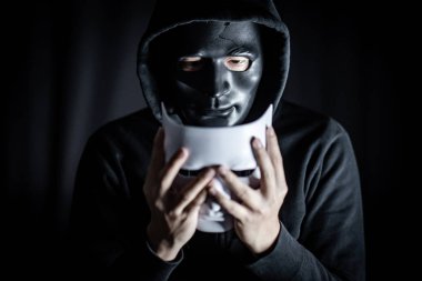 Gizem hoody giyiyor kırık siyah maske holding beyaz maske dostum. Anonim sosyal maskeleme. Major depresif bozukluk ya da bipolar bozukluk. Cadılar Bayramı kavramı