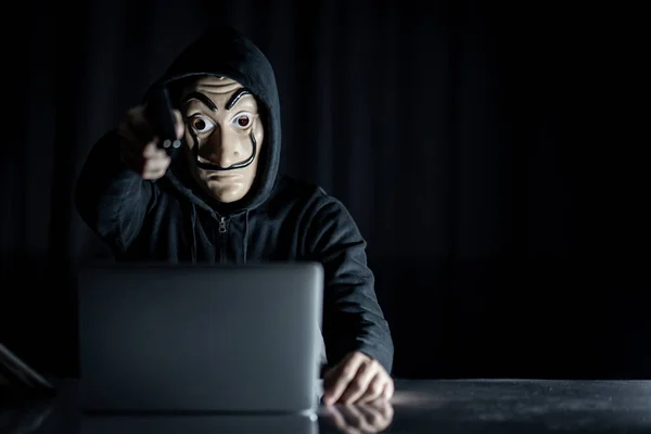 Homem Hoodie Hacker Vestindo Máscara Misteriosa Segurando Arma Enquanto Sentado — Fotografia de Stock