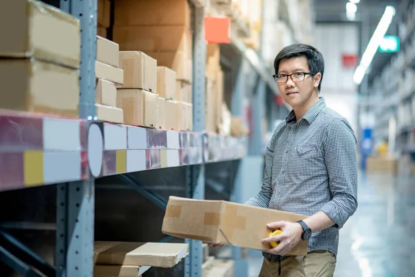 Joven Hombre Asiático Que Lleva Caja Cartón Entre Fila Estantes — Foto de Stock