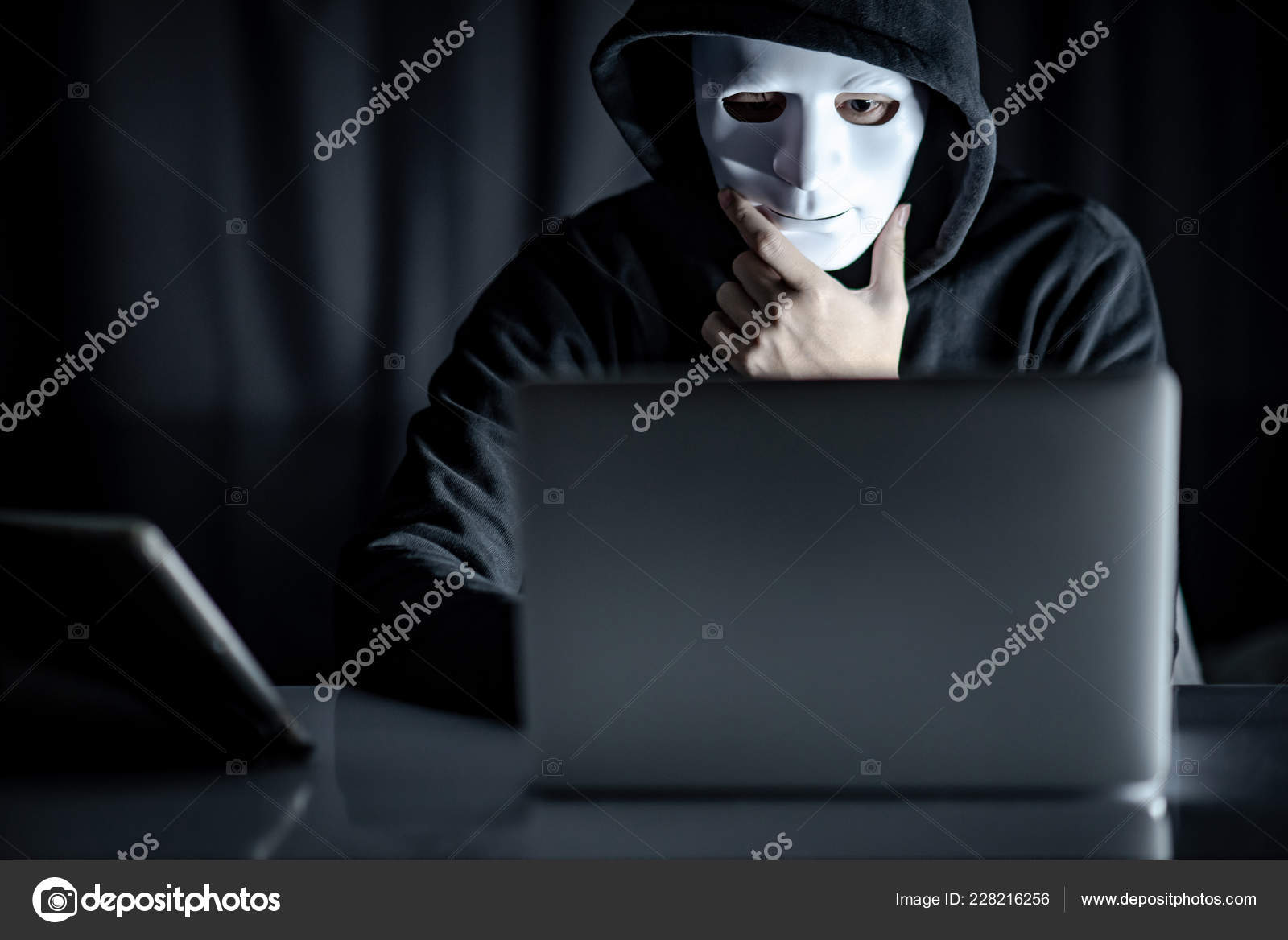 拿着白色面具看着笔记本电脑的黑客——图库图片© zephyr18 #228216256