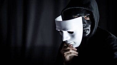 Beyaz maske tutarak siyah maskeli gizemli adam