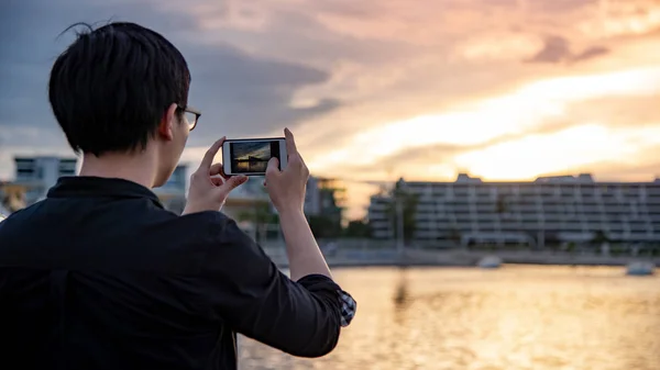 Ázsiai ember vesz a naplemente fénykép smartphone — Stock Fotó