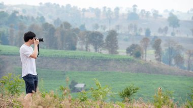 Dijital fotoğraf makinesi alarak fotoğraf dağ manzaralı peyzaj kullanarak Asya adam gezgin. Yaşam tarzı ya da doğa fotoğraf kavramları seyahat