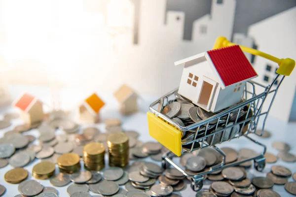 不動産または特性の投資概念 住宅ローン貸付利率 建設事業投資家のモデルとミニのショッピングカート トロリー と都市背景とテーブルの上のコイン — ストック写真