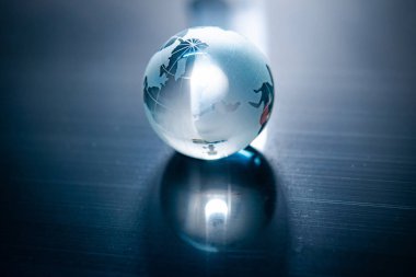 Dünya küre kristal cam mavi parlak masaya yansıtır. Küresel iş ve ekonomi. Çevre koruma veya ekoloji kavramı