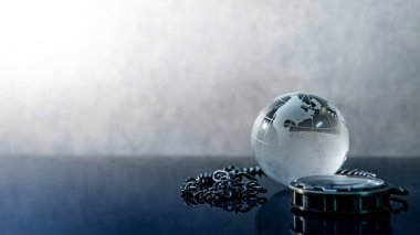 Küresel iş kavramı. Dünya küre kristal cam ve gümüş cep parlak masaya dikkat et. Zaman yönetimi ve yatırım. 