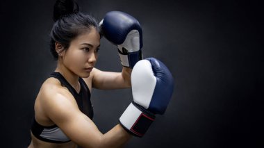 Genç Asyalı kadın boksör aparkat fitness salonunda mavi boks eldivenli poz. Kadın boks sınıf. Dövüş sanatları kavramları