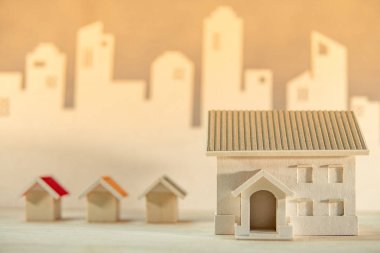 Gayri menkul ya da gayrimenkul yatırım. Ev tasarım konsepti. Ev modelleri şehir manzarası arka plan ile masada. Konut Yapı Geliştirme