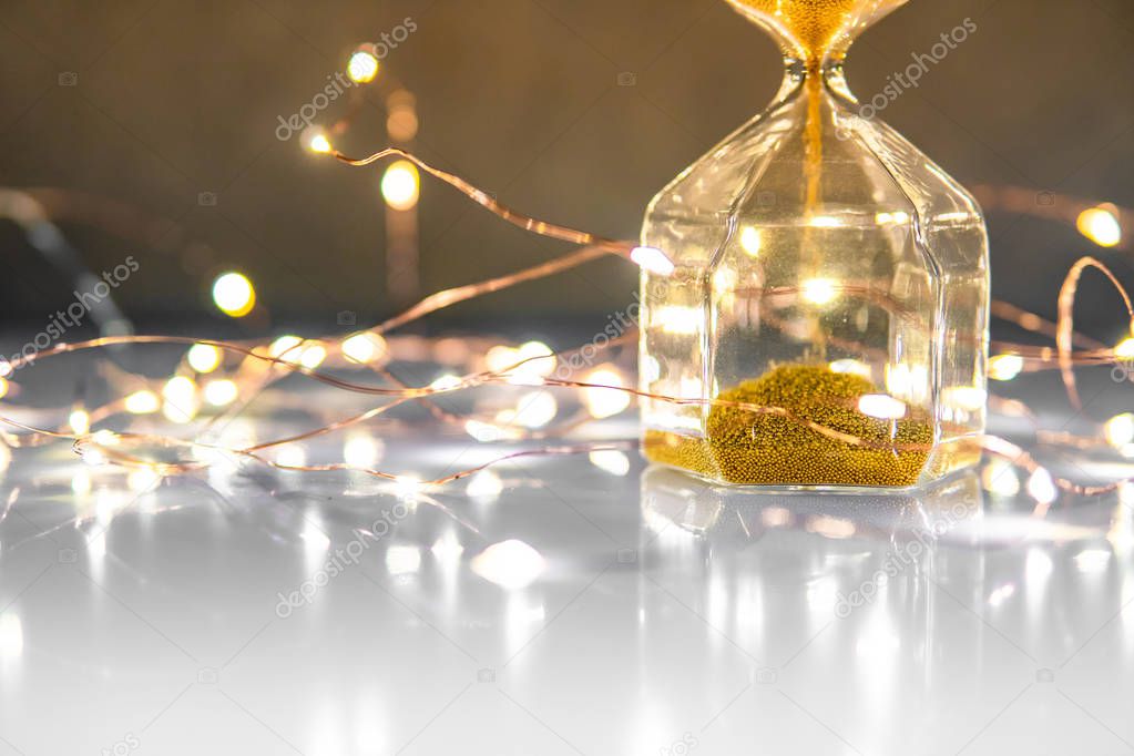 Gold sand running through the shape of hourglass on glossy table.Time passing and running out of time. Urgency countdown timer for business deadline concept