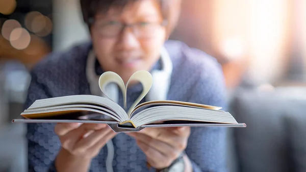 亚洲快乐的人拿着书与心脏形状页折叠在中心 为世界图书日读书 爱情和情人节的概念 — 图库照片